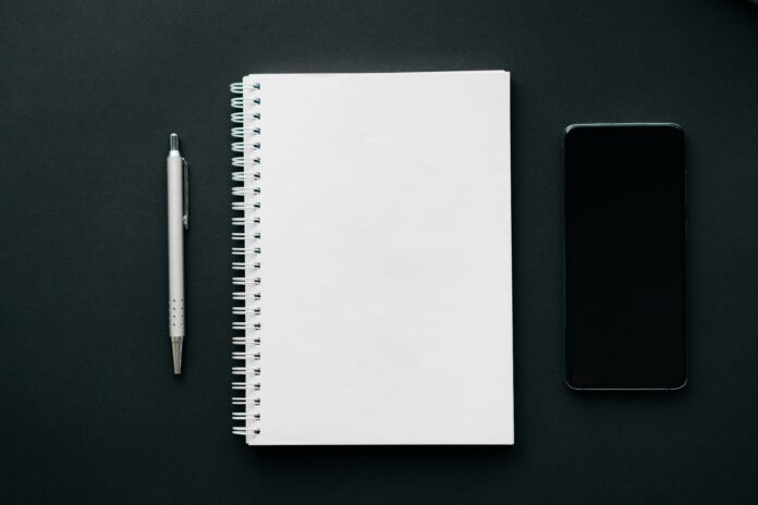 a notebook, pen and a mobile