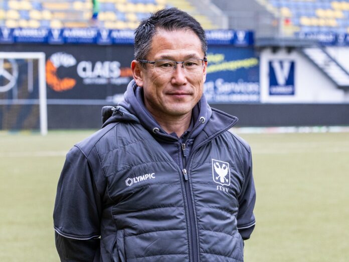 Tsuyoshi Takano standing on a football pitch in STVV training gear, with a focused expression, during his time at the Belgian club.