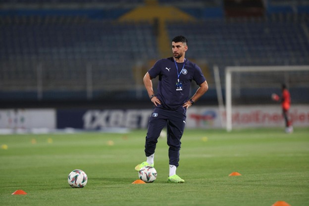 Islam Gamal Ahmed standing on the pitch during a training session with Pyramids FC, wearing official team gear and surrounded by footballs and cones.