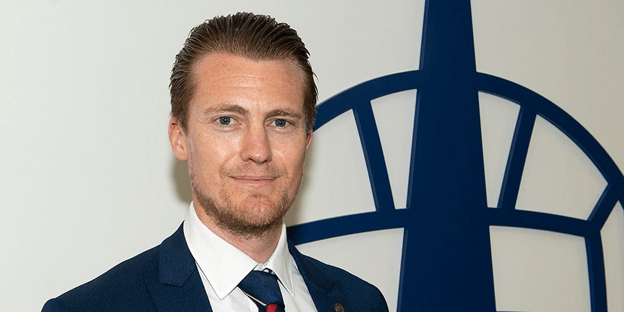 Jamie Swinney, CEO of Falkirk FC, standing in front of the club emblem