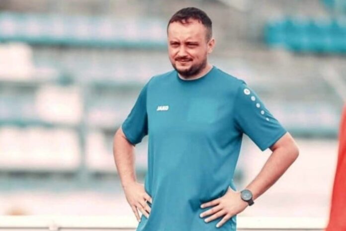 Slawomir Morawski standing on the sideline in a blue JAKO training kit, observing a session and applying cognitive training in football.
