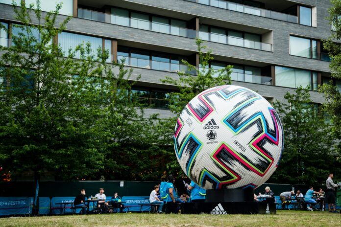 Giant Adidas Uniforia football on display at a UEFA Festival event, symbolizing European football branding and sponsorship.