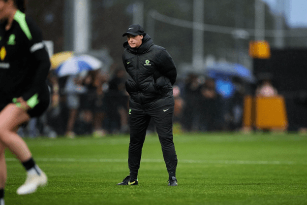 Kat Smith coaching on the training pitch in wet conditions, showcasing her role as a leading figure in Australian women’s football.