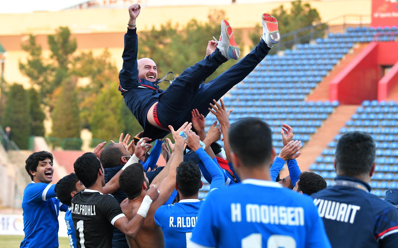Kuwait U-23 players lift coach Carlos González into the air in celebration after securing historic qualification for the AFC U-23 Asian Cup.