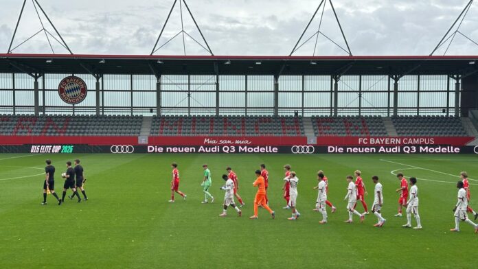 Youth football players walk out for a match at FC Bayern Campus, highlighting the pressure of elite academy environments.