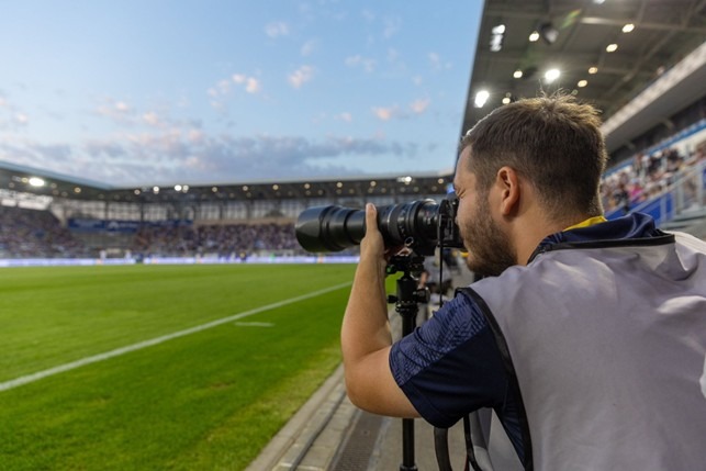 Hannes Anger photographing a football match from the sidelines at FC Carl Zeiss Jena’s stadium.