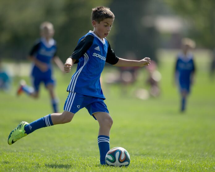 Soccer Minor Player Youth football player controlling the ball during a match, representing issues around international transfers of minor players.