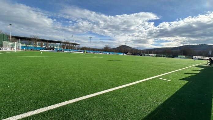 AoS Football pitch highlighting space and positioning during a youth match under clear skies.