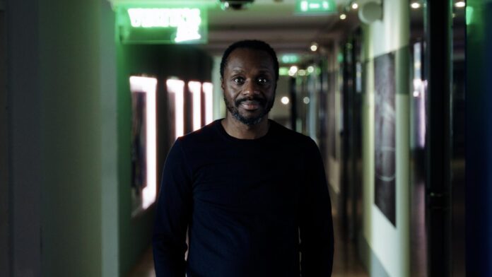 Ben Manga standing in a stadium hallway, reflecting his role as one of European football’s leading scouting and talent directors.