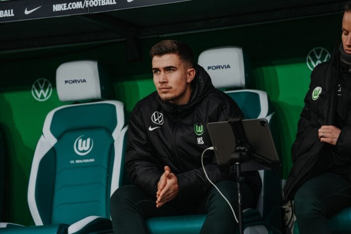 Marcel Schulz Marcel Schulz seated on the VfL Wolfsburg bench during a Frauen-Bundesliga match, focused and analysing play.