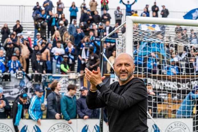 Patrice Gheisar applauds supporters during a matchday moment in the Canadian Premier League.