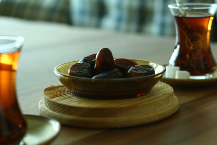 Dates and Tea Dates and Turkish tea on a wooden table symbolising Ramadan fasting and matchday nutrition in football.