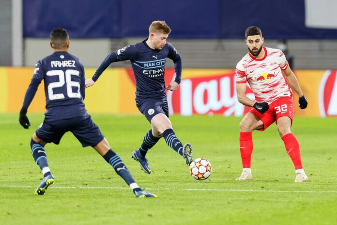 KDB Kevin De Bruyne plays a forward pass for Manchester City under pressure in a Champions League match