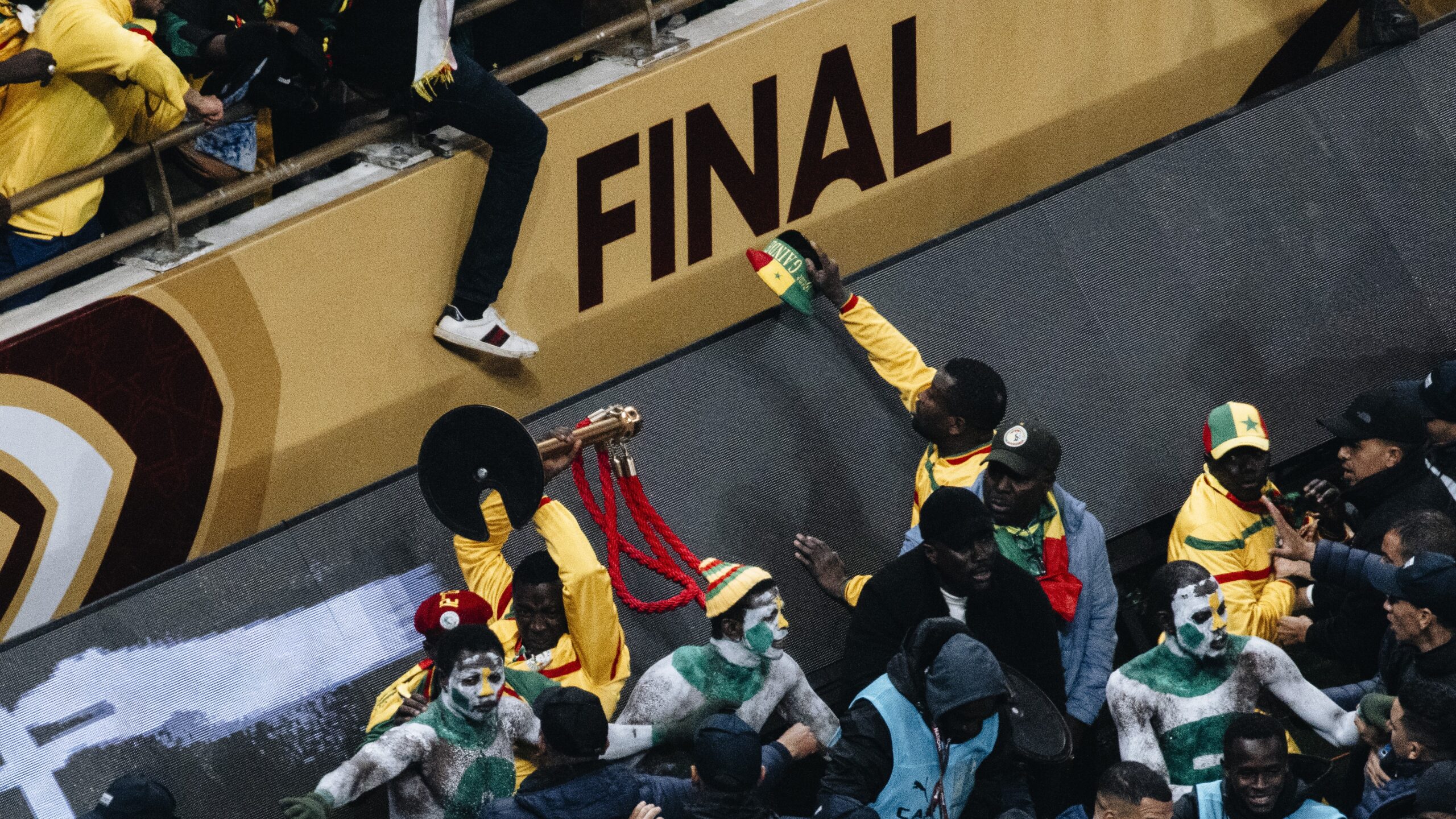 Security personnel intervene as Senegal supporters gather near the pitch during the AFCON 2025 final.