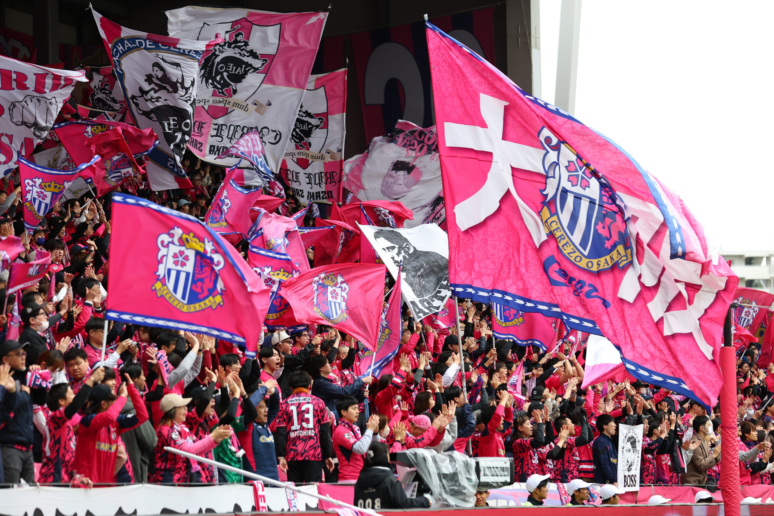 Cerezo Osaka fans wave pink flags in the stands showcasing identity and passionate supporter culture in Japan
