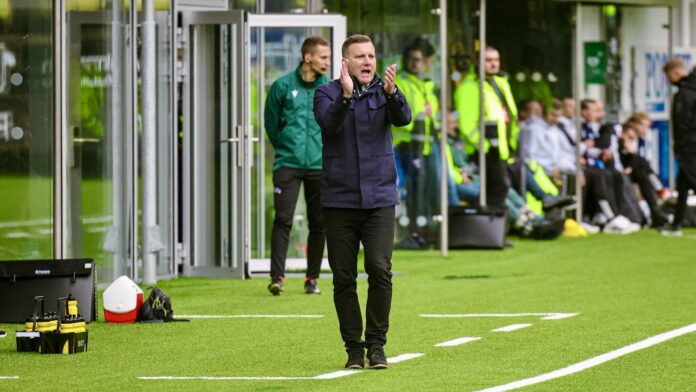 Jens Wedeborg coaching from the touchline during a match, directing his team with tactical instructions.