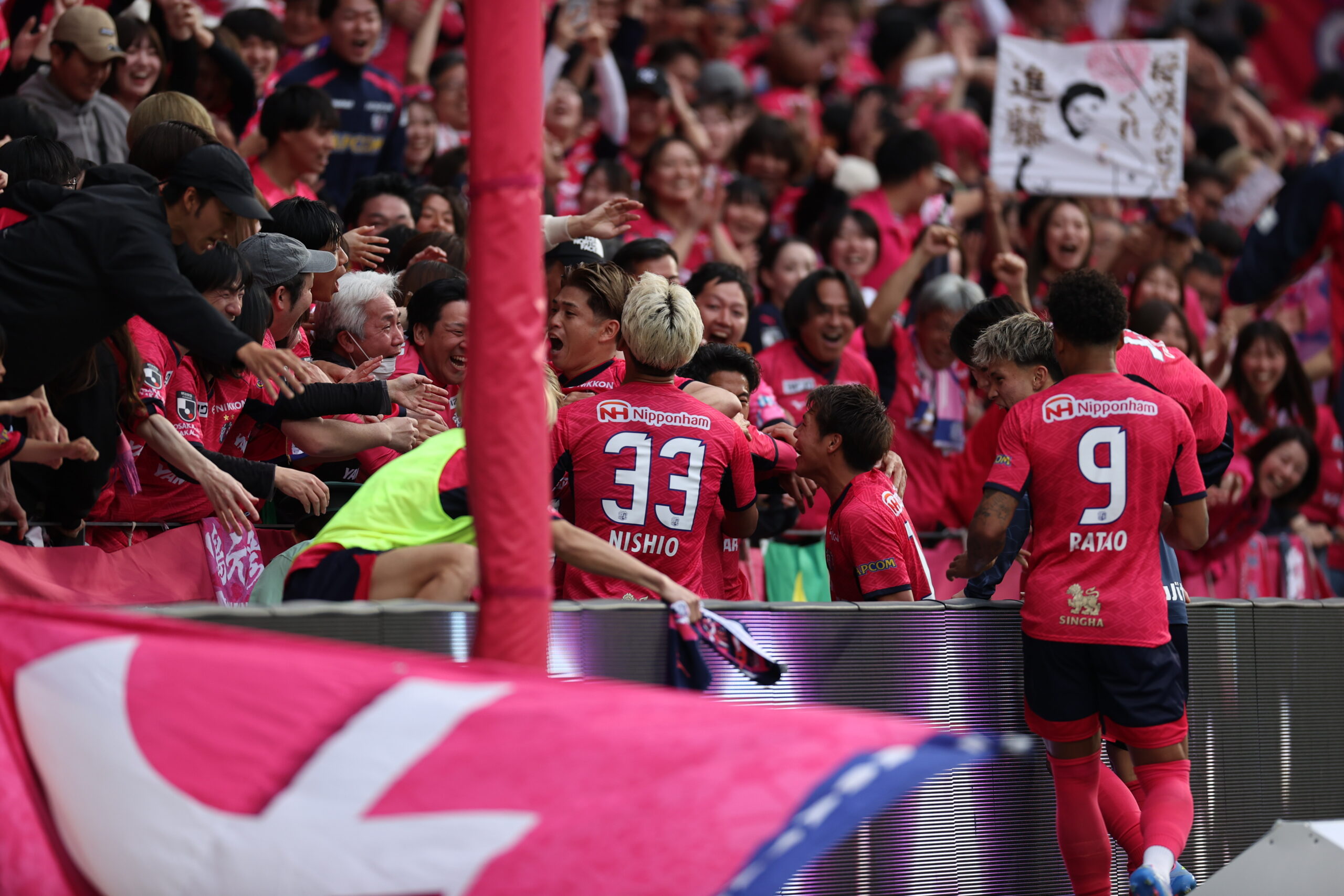 Cerezo Osaka players celebrate decisive goal against Kashima Antlers with fans, capturing emotional connection