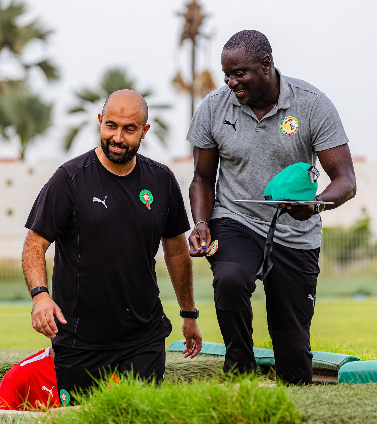 Zakarya Oumouche working with coaching staff during a training session for youth football development in Morocco.