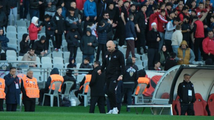 Onur Can Korkmaz on the touchline during a match, demonstrating leadership and focus in a high-pressure environment