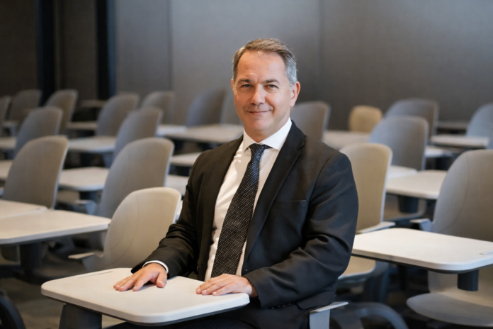 Dr Erden Or seated in a lecture room reflecting football leadership and education