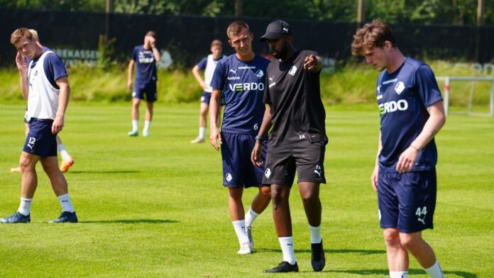 Fatah Abdirahman at Randers FC stadium with colleague, highlighting his role in Danish professional football