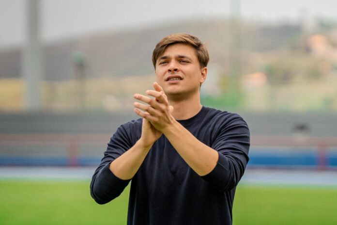 Toni Cruz coaching from the touchline, applauding during a football training session