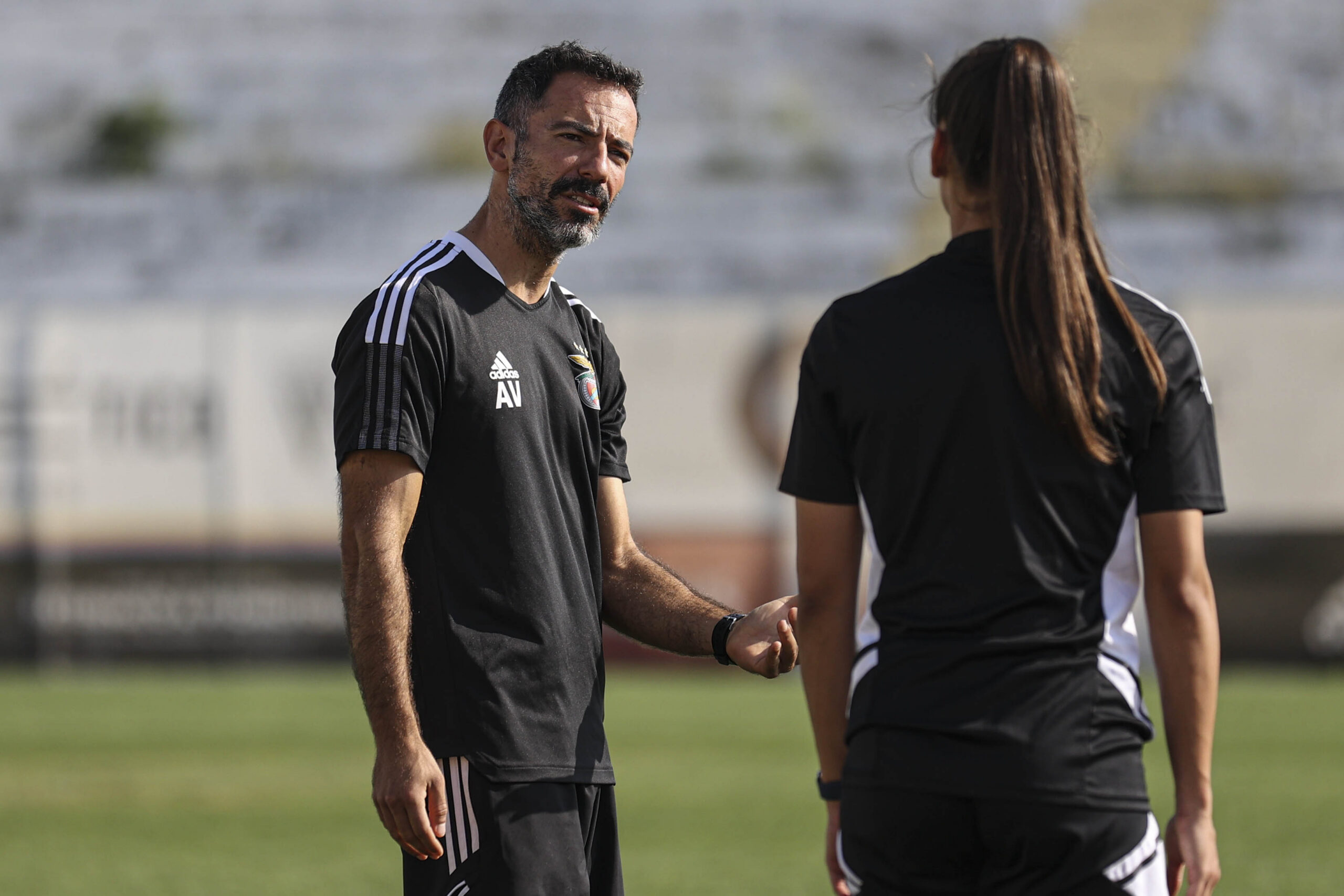 André Vale speaking with a women’s football player during training.