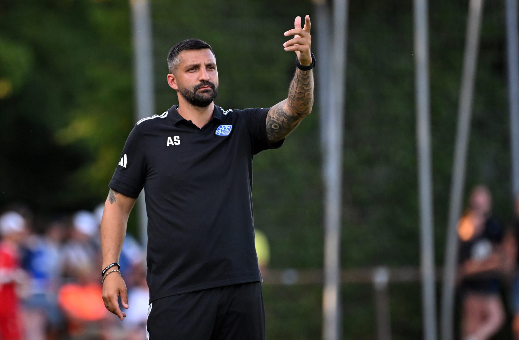 Aytaç Sulu gives instructions from the touchline during a football match as a coach.