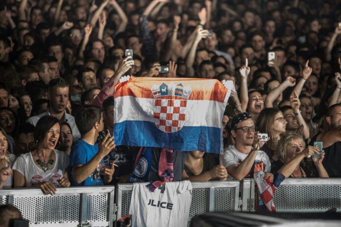 Croatian football fans hold a national flag during a match, reflecting the country’s strong football culture and passion