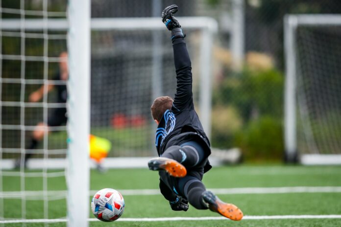 Goalkeeper diving during training, highlighting modern goalkeeper development and academy football pathways.
