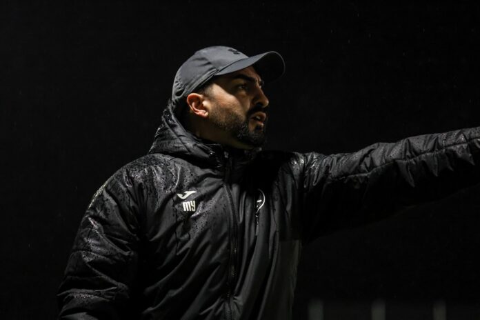 Marco Yurtseven coaching in wet conditions, highlighting youth football leadership and player development.