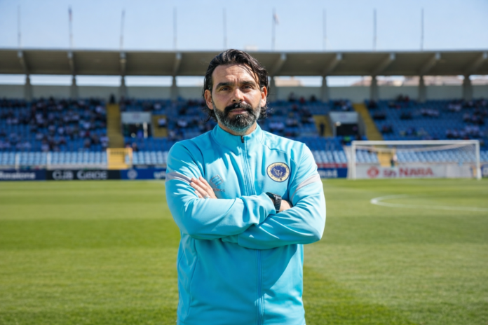 Cenk Özcan, UEFA Pro Licence coach, standing pitchside during a professional football training session.