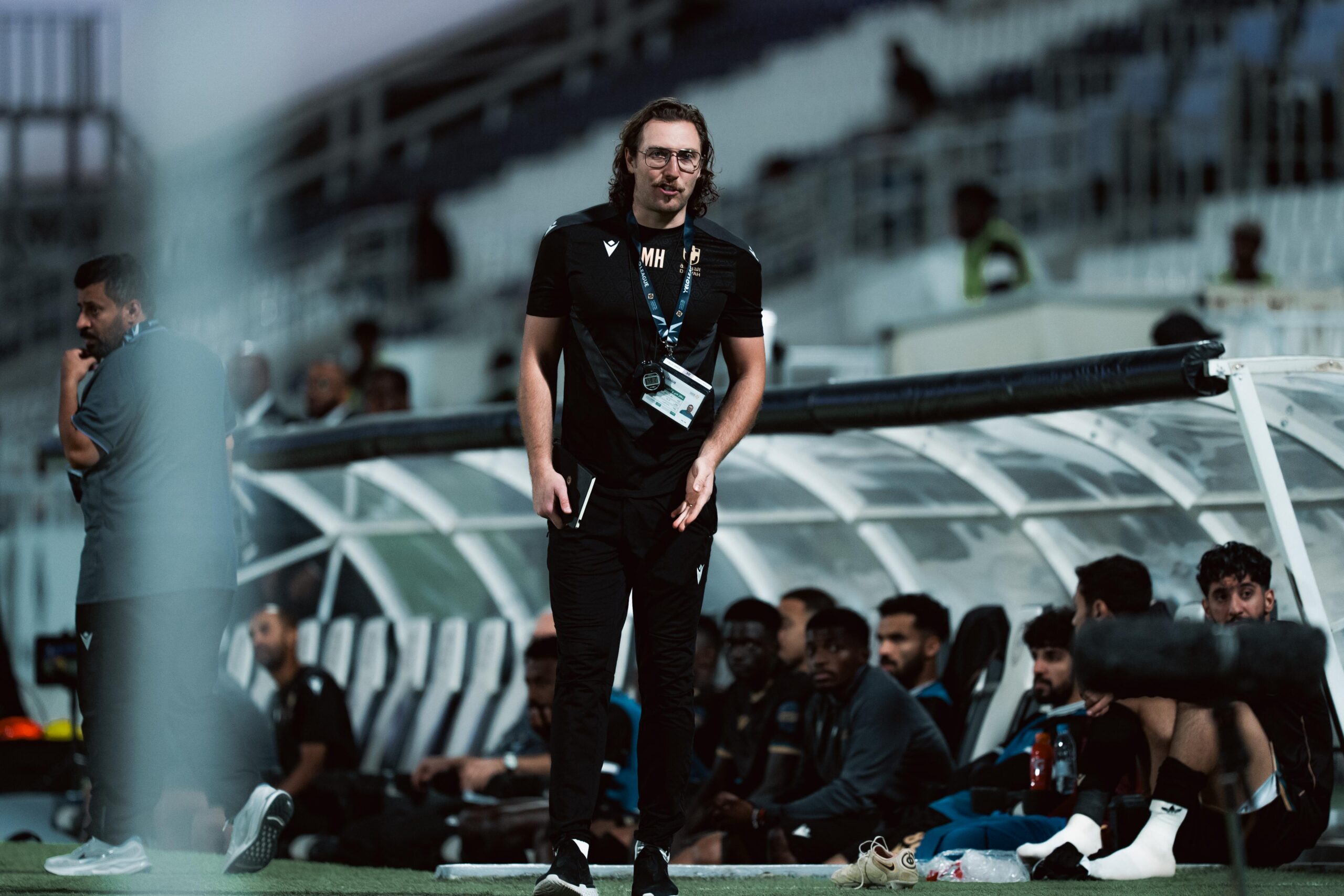 Michael Hefele on the touchline with Al Diraiyah, highlighting his work in coaching and player development.