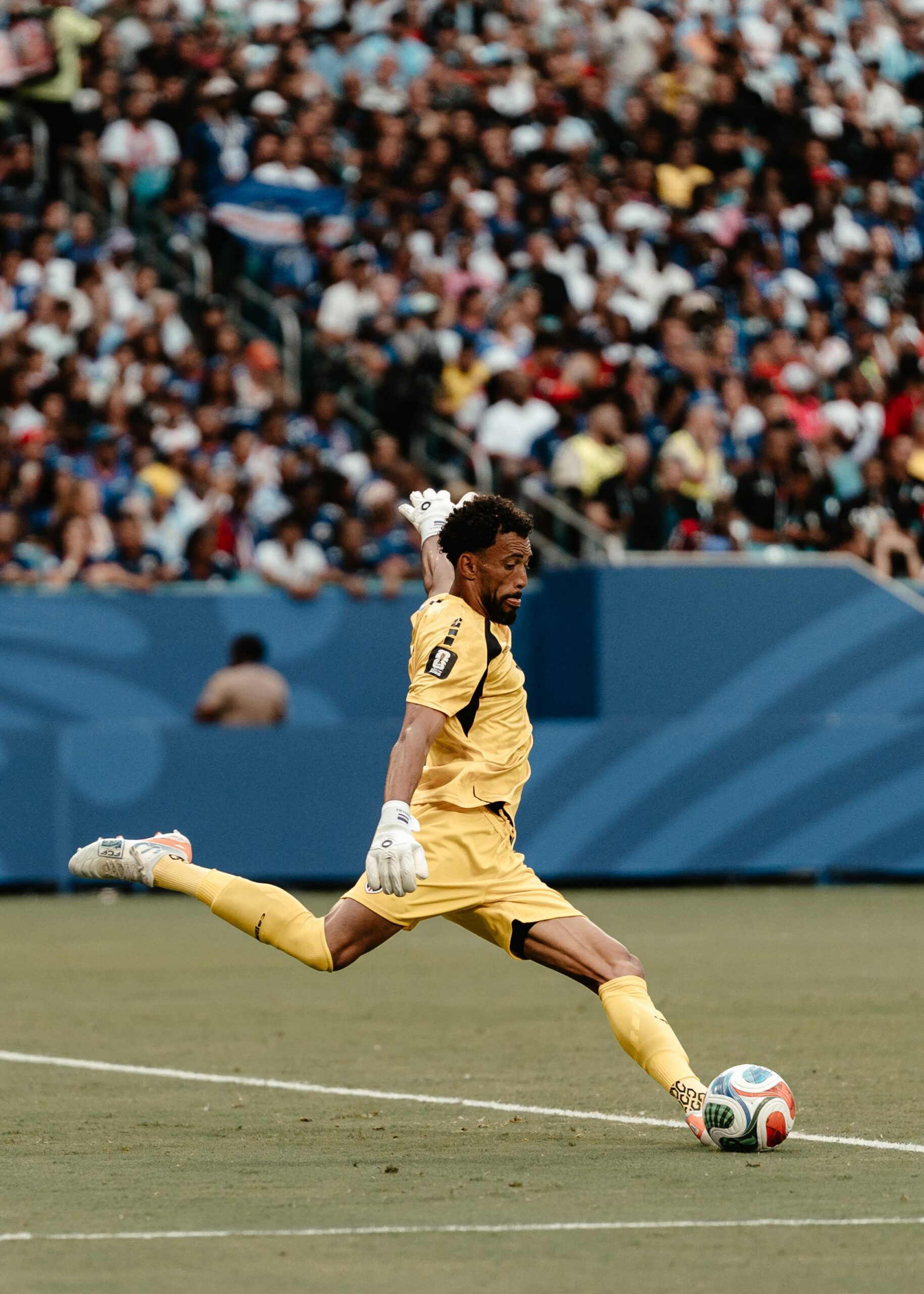 Vozinha kicks the ball in Cape Verde’s yellow goalkeeper kit at the World Cup.