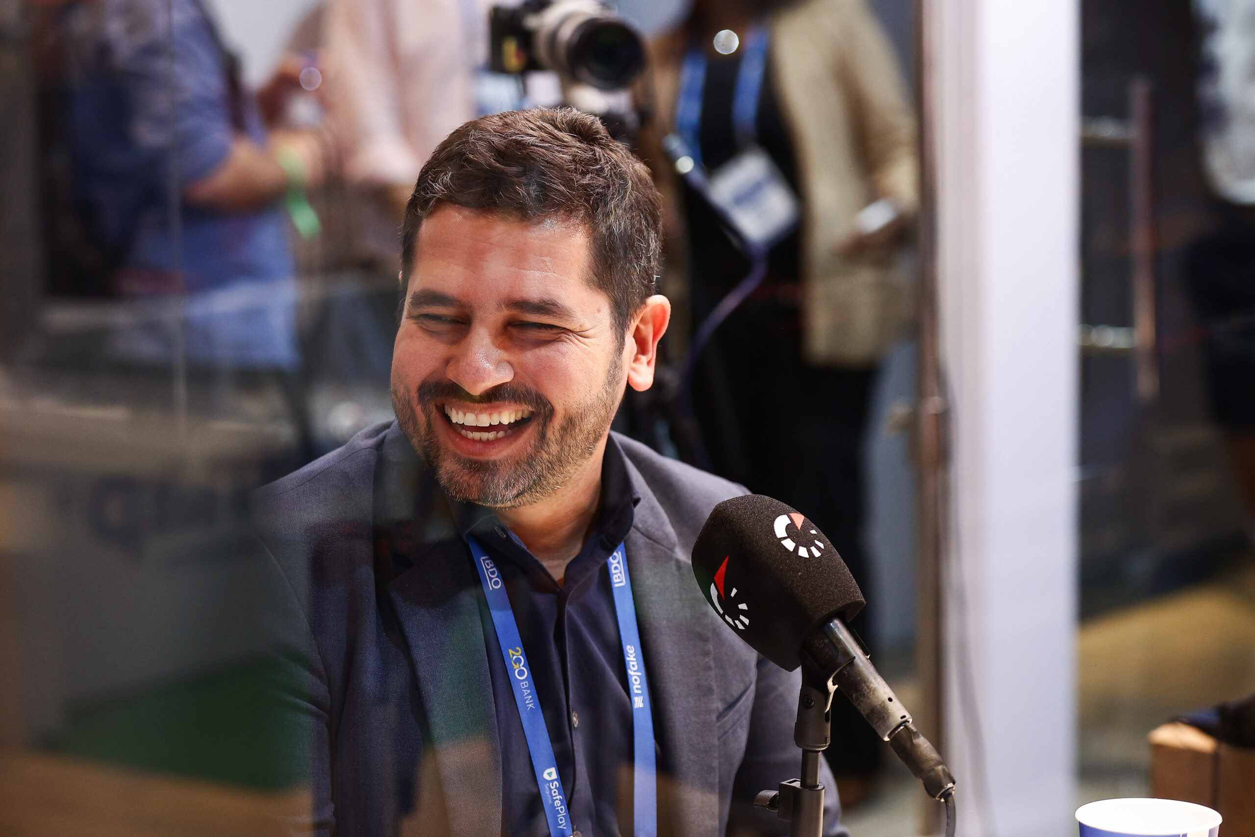 Confut USA CEO speaking into a microphone during a football business media interview.