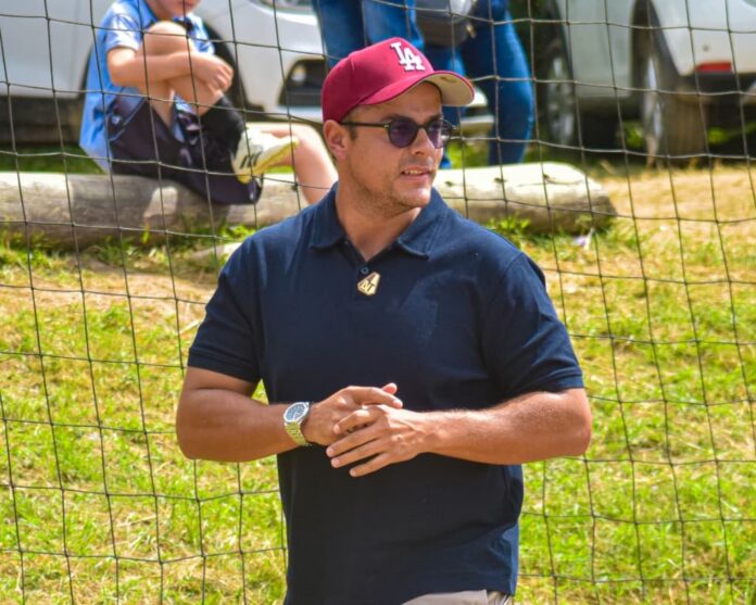 Football executive observing play, reflecting sporting strategy and talent development.