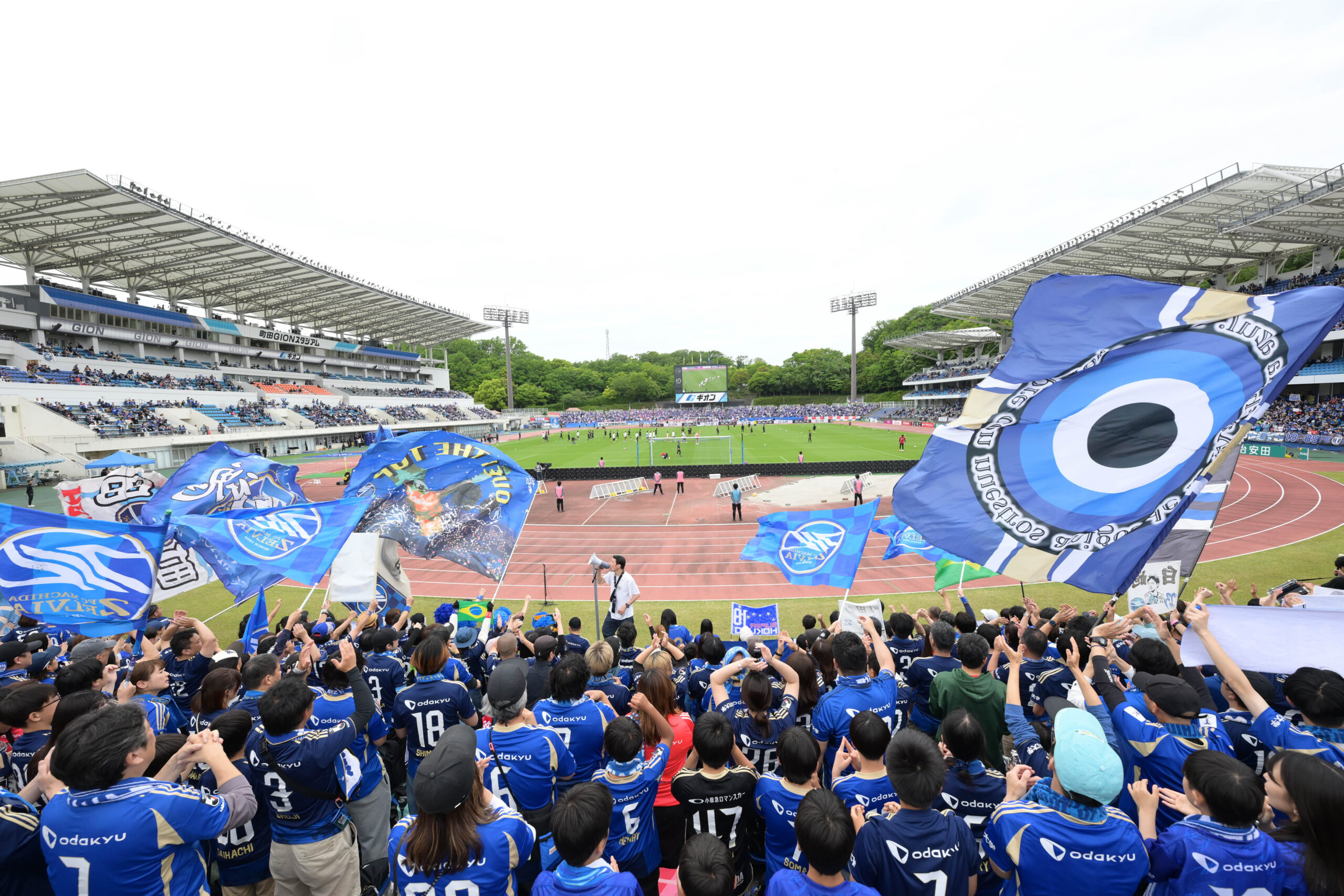 FC Machida Zelvia supporters wave flags inside a packed stadium