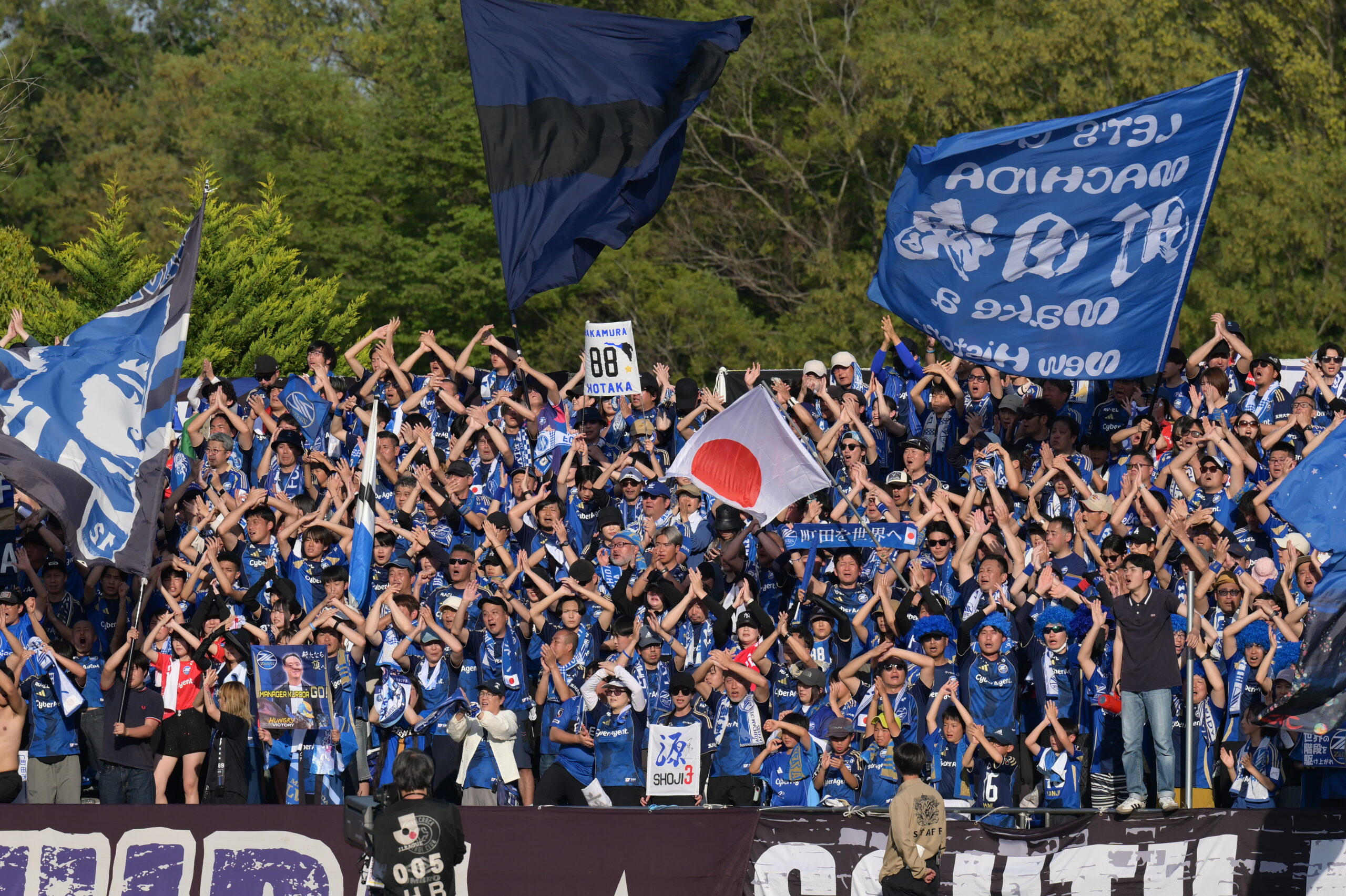 FC Machida Zelvia supporters fill the stand with blue flags and banners