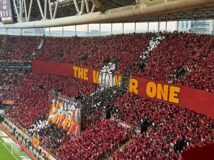 Galatasaray taraftarları tribünde koreografiyle takımlarını desteklerken Türk futbolundaki taraftar baskısını yansıtıyor.