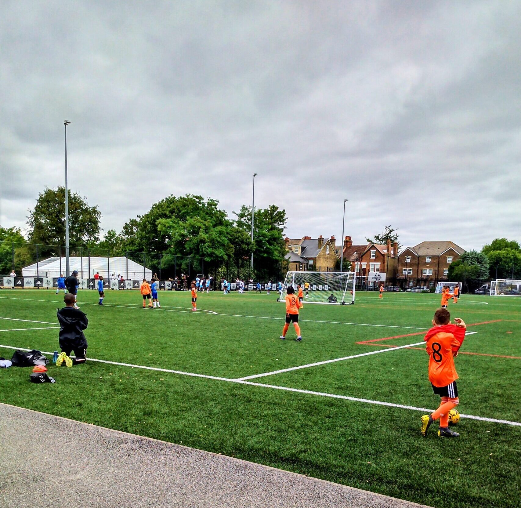 Young footballers playing on a community football pitch, highlighting the importance of accessible spaces for grassroots development.