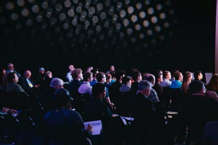 Conference audience attending a professional event, illustrating how to organize a low-budget football event.