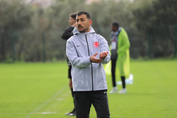 Selçuk Erdoğan leads a Turkey youth national team training session in wet conditions.
