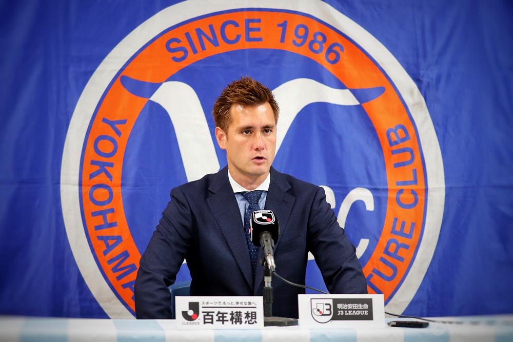 Yuki Stalph speaking at a Yokohama SCC press conference during his coaching career in Japan.