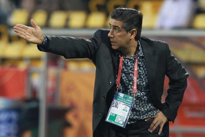 Afshin Ghotbi gives instructions from the touchline during a football match.