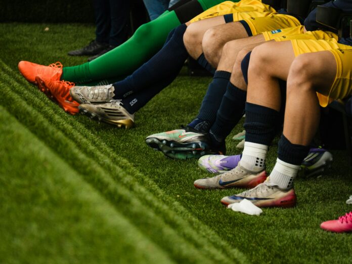 Football players sitting on the substitutes’ bench, illustrating the MLS waivers and player movement process.