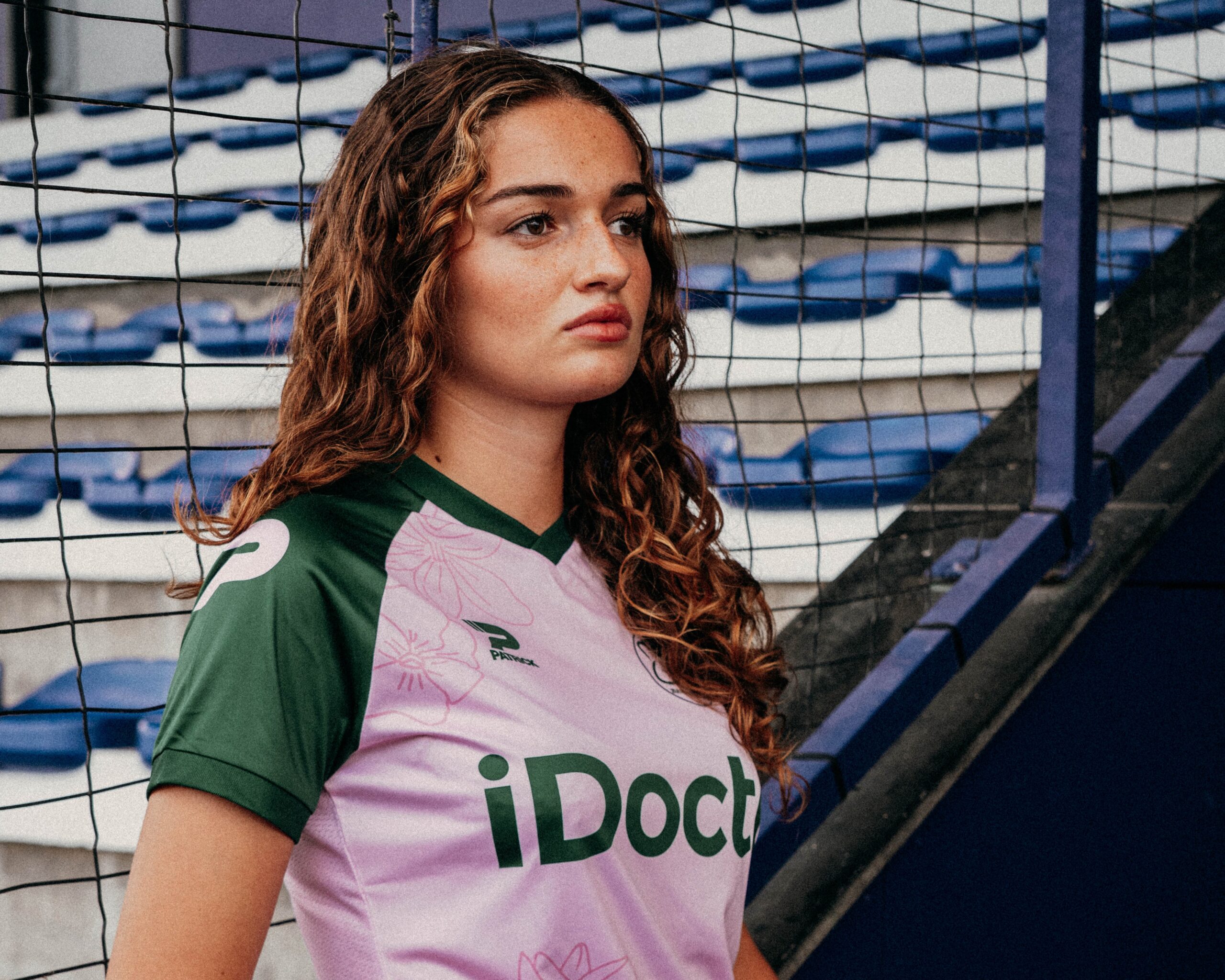 Essevee Women’s 2026/27 away shirt features a light pink base, dark green sleeves and floral illustrations.