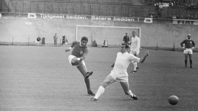 Eusébio strikes the ball for Benfica against Ajax during a friendly match in Amsterdam in May 1965.