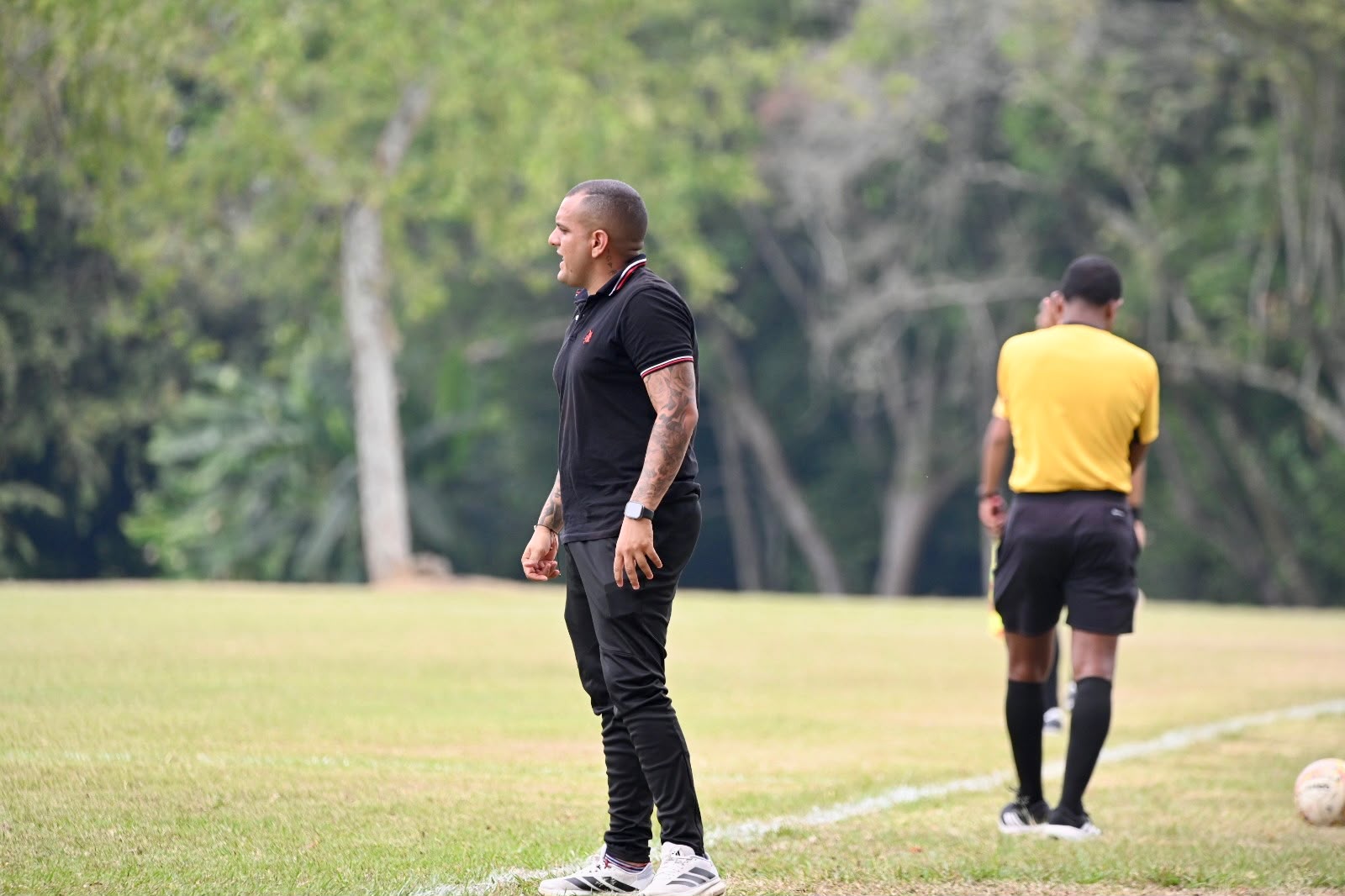 Juan David Díaz Florián coaching from the touchline, demonstrating his hands-on approach to football development.