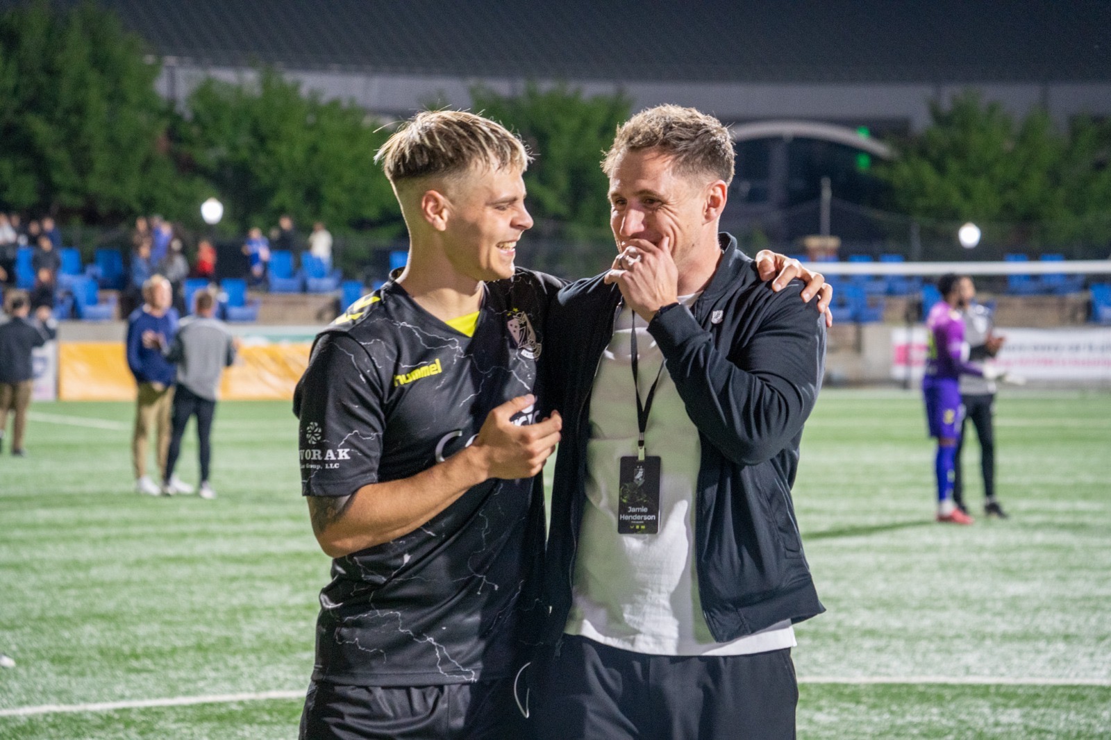 Union Omaha sporting director Jamie Henderson shares a moment with a player on the pitch after a match.
