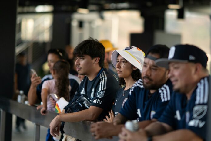 Soccer supporters watching a match from the stands at Snapdragon Stadium in San Diego, reflecting American soccer culture.